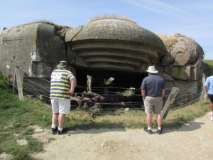 Father and two sons from Oklahoma look at one of the blasted bunkers above Arromanches-les-Bains