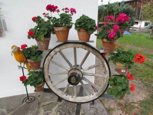 This homeowner has decorated using an old wagon wheel along with potted flowers near Kitzbuehl